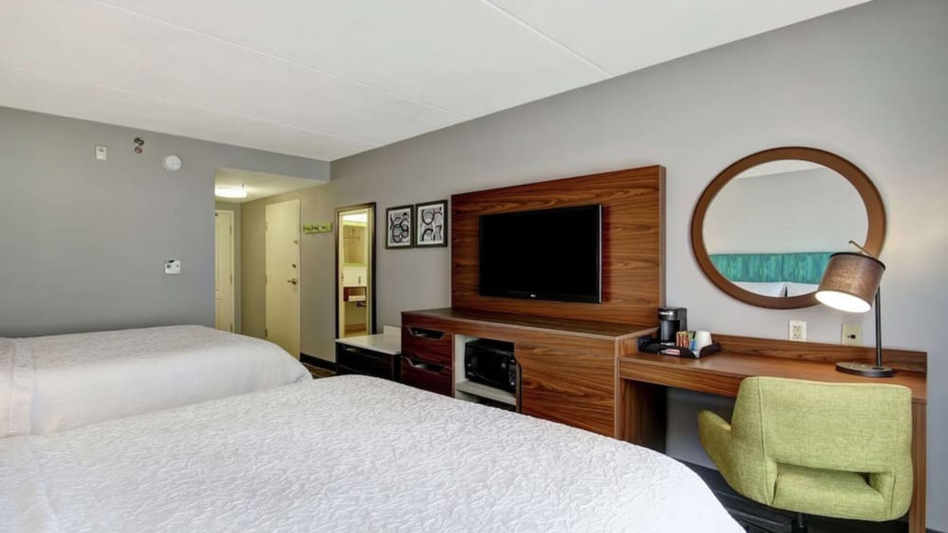 Guest room with two queen beds, work desk, TV, microwave, and mini fridge at Hampton Inn & Suites By Hilton Guelph.