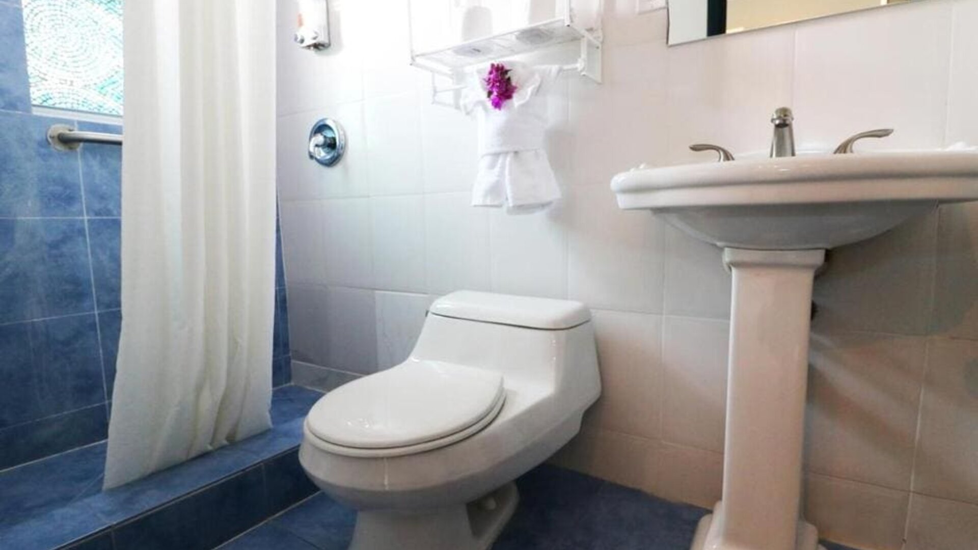 Guest bathroom with shower at Hollywood Beach Suites, A South Beach Group Hotel.