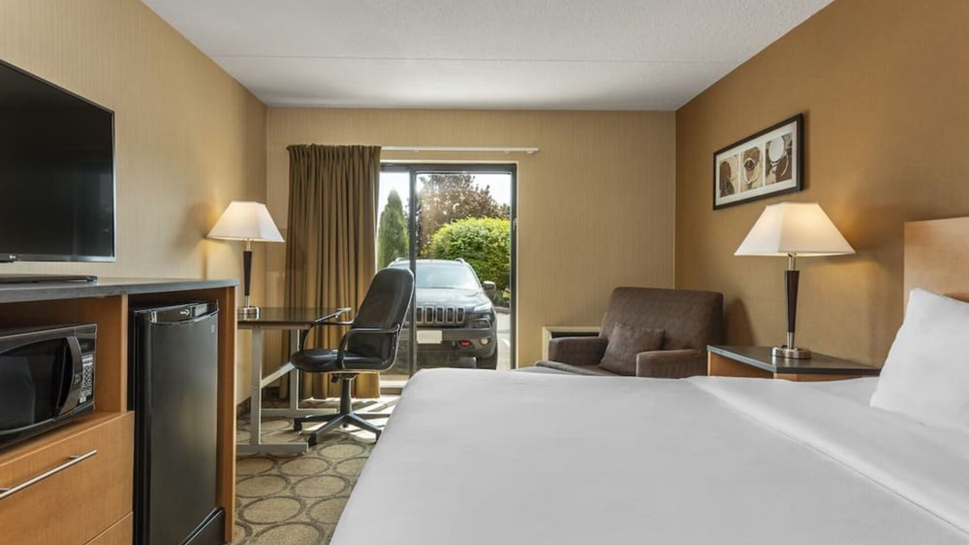 Guest room with a king bed, work desk, and armchair at Comfort Inn Brandon.