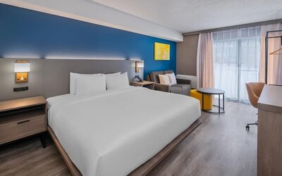 Guest room with a king bed, sofa, and workspace at Comfort Inn Belleville.