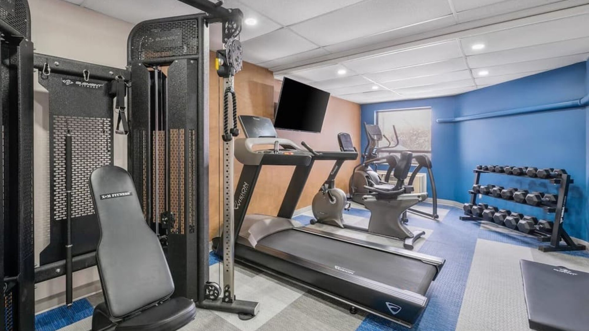 Fitness center with cardio machines, free weights, and strength equipment at Comfort Inn Belleville.