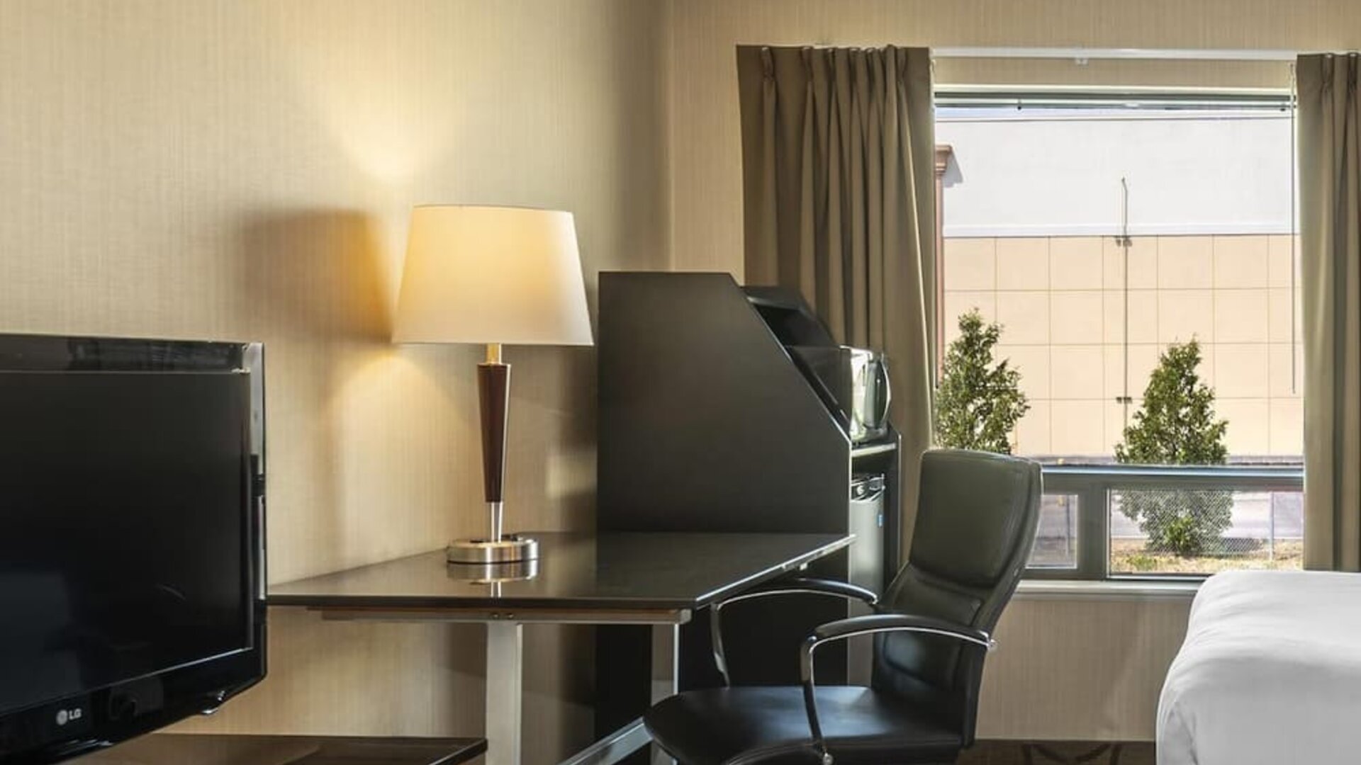 In-room workspace with a desk, TV, and mini fridge at Comfort Inn Swift Current.