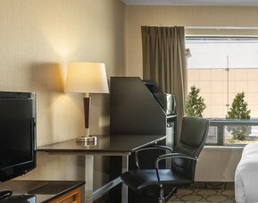 In-room workspace with a desk, TV, and mini fridge at Comfort Inn Swift Current.