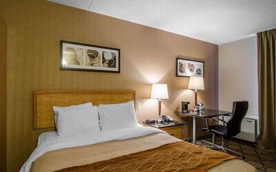 Guest room with a queen bed and work desk at Comfort Inn Swift Current.