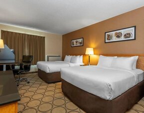 Spacious guest room with two queen beds and modern furnishings at Comfort Inn Swift Current.