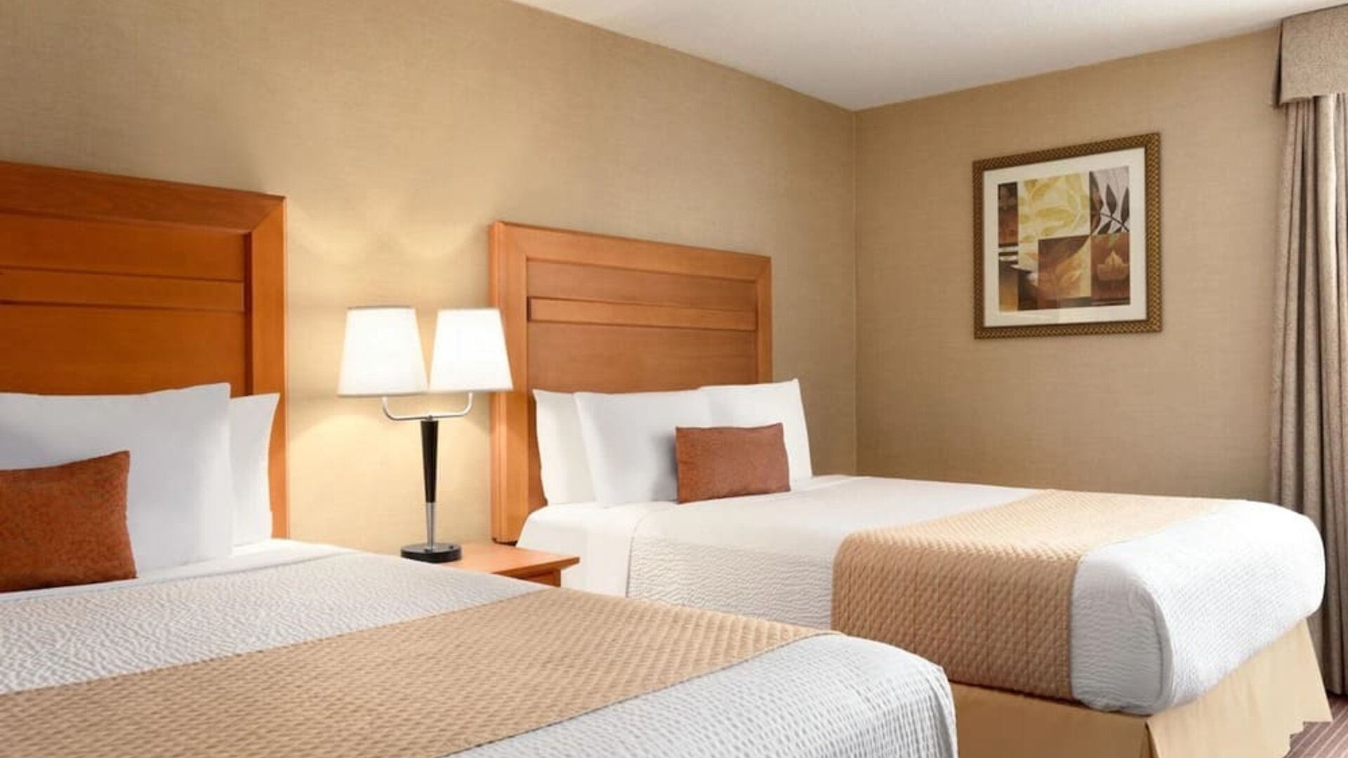 Guest room with two double beds and bedside lighting at Days Inn Edmonton Downtown.