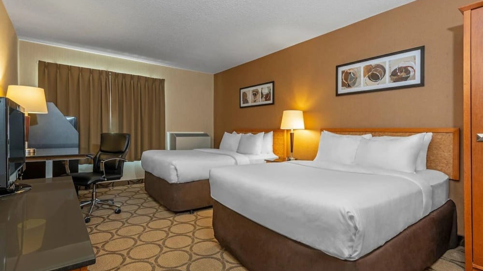 Spacious guest room with two queen beds and a work desk at Comfort Inn Edmonton West.