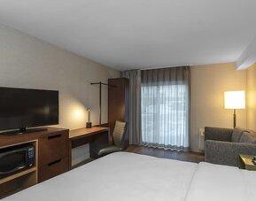 Guest room with a king bed, sofa, work desk, and flat-screen TV at Comfort Inn Ottawa East.