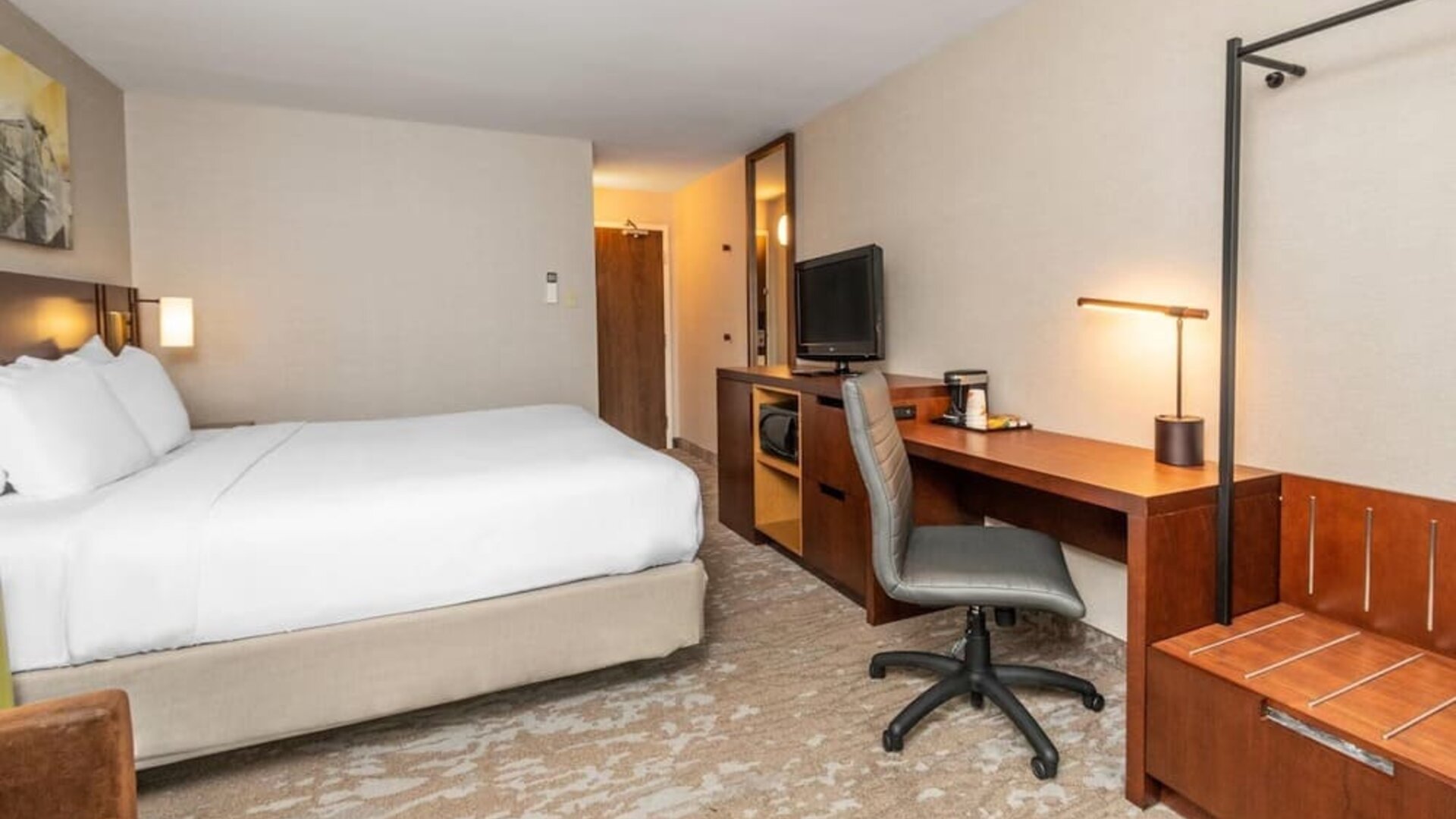Guest room with a king bed, work desk, and luggage rack at Comfort Inn Ottawa East.