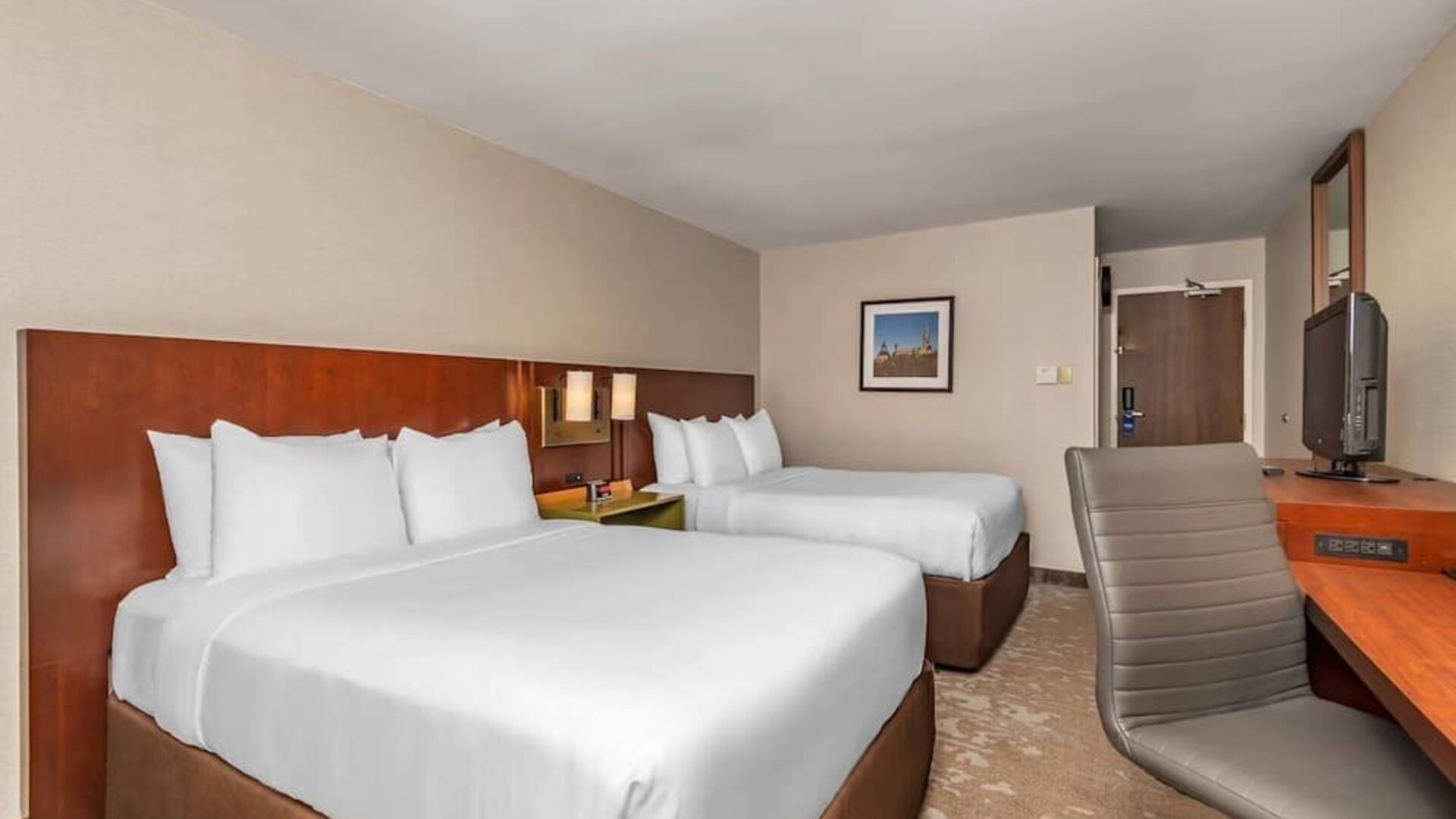 Guest room with two queen beds, flat-screen TV, and work desk at Comfort Inn Ottawa East.