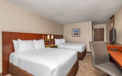Guest room with two queen beds, flat-screen TV, and work desk at Comfort Inn Ottawa East.