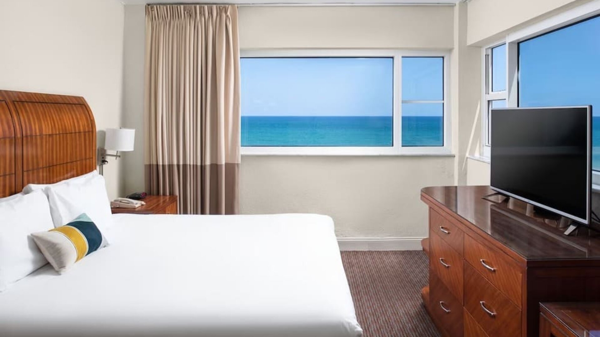 Guest room with a king bed and panoramic ocean view at Sherry Frontenac Oceanfront Hotel.