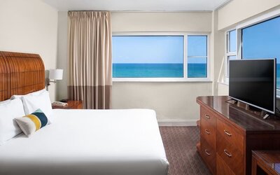 Guest room with a king bed and panoramic ocean view at Sherry Frontenac Oceanfront Hotel.