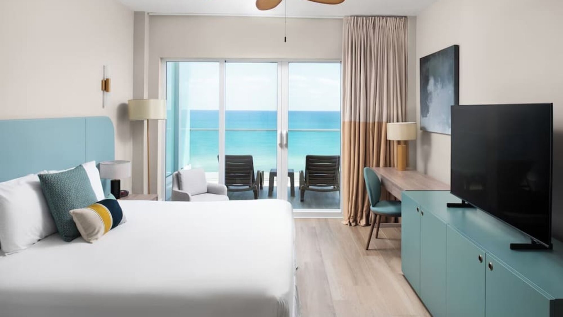 Oceanfront guest room with a private balcony and king bed at Sherry Frontenac Oceanfront Hotel.