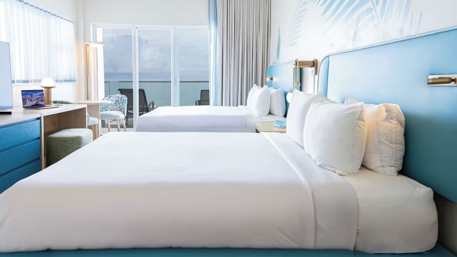 Oceanfront guest room with two queen beds and balcony access at Sherry Frontenac Oceanfront Hotel.