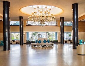 Grand hotel lobby with chandelier and lounge seating at Sherry Frontenac Oceanfront Hotel.