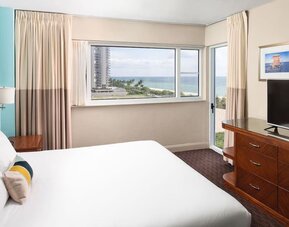 Guest room with a king bed and ocean view at Sherry Frontenac Oceanfront Hotel.
