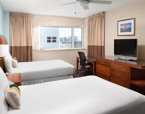 Guest room with two queen beds and tropical décor at Sherry Frontenac Oceanfront Hotel.