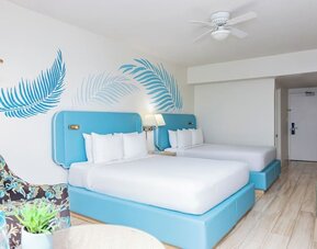 Guest room with two double beds and modern furnishings at Sherry Frontenac Oceanfront Hotel.