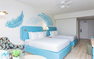 Guest room with two double beds and modern furnishings at Sherry Frontenac Oceanfront Hotel.