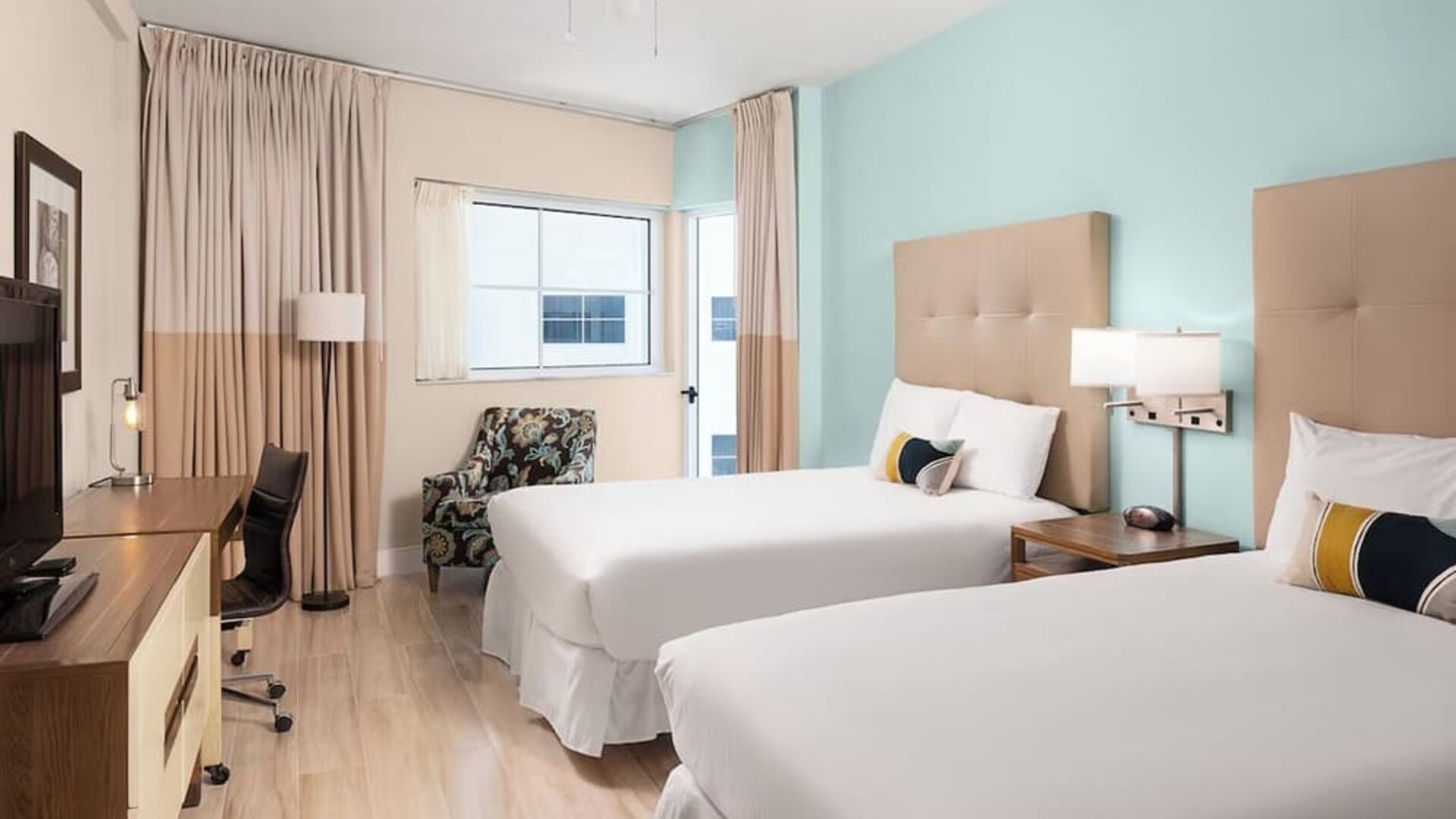 Guest room with two queen beds and work desk at Sherry Frontenac Oceanfront Hotel.