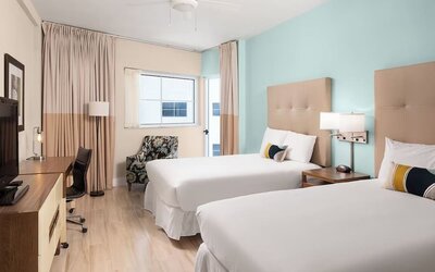Guest room with two queen beds and work desk at Sherry Frontenac Oceanfront Hotel.