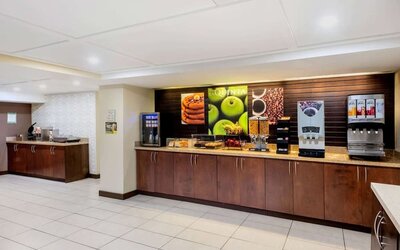 Breakfast area with self-serve coffee, juice, and buffet stations at La Quinta Inn & Suites By Wyndham Oshawa.