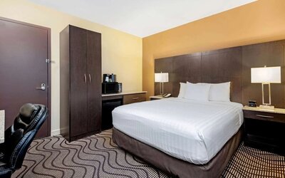 Guest room with a king bed, microwave, and mini fridge at La Quinta Inn & Suites By Wyndham Oshawa.