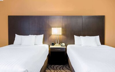 Guest room with two queen beds and work area at La Quinta Inn & Suites By Wyndham Oshawa.