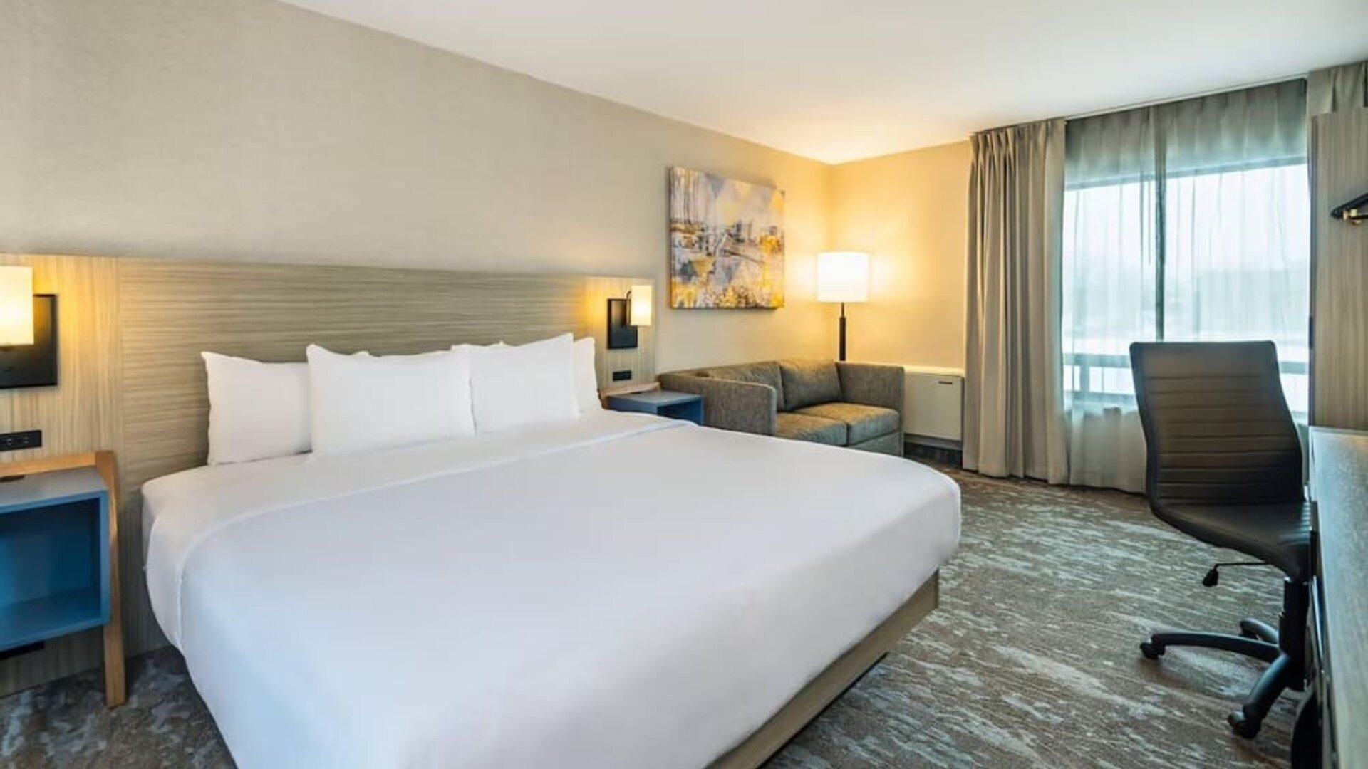 Spacious guest room with a king bed and seating area at Comfort Inn Saskatoon.