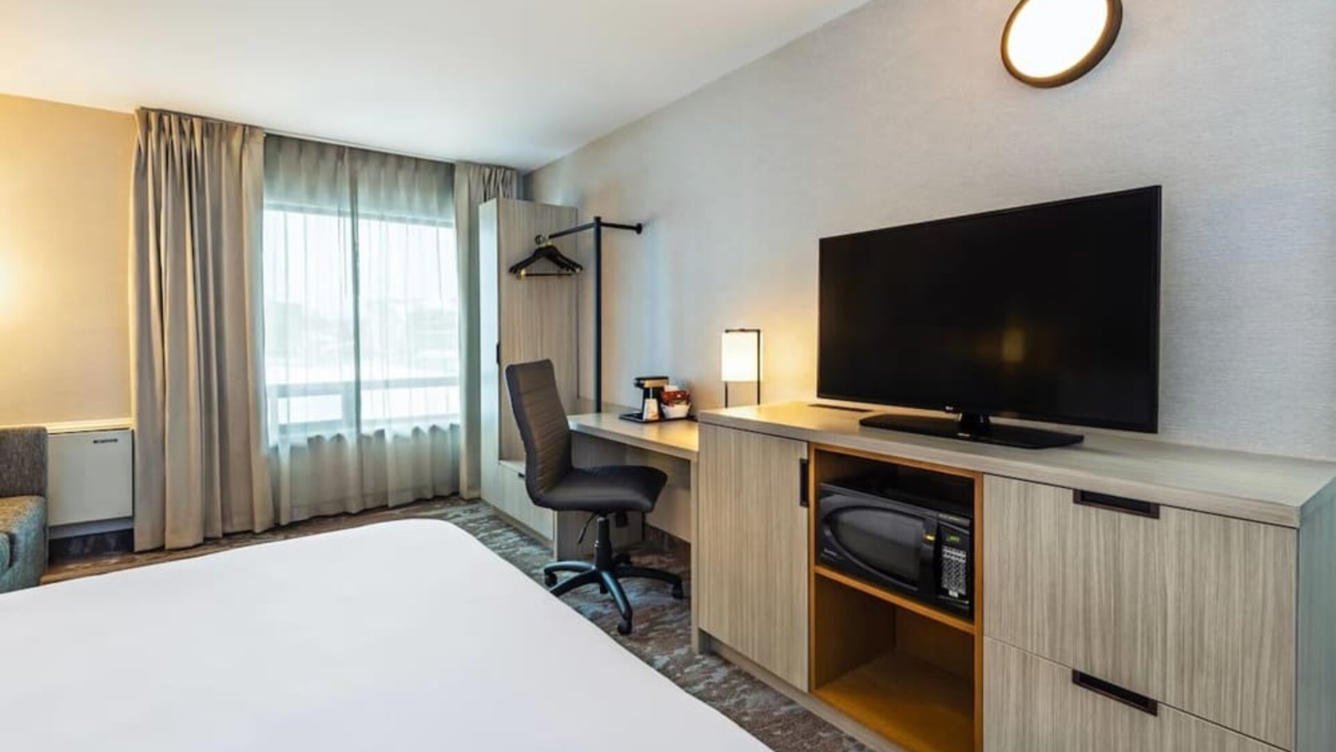 Guest room workspace with a desk, TV, and microwave at Comfort Inn Saskatoon.