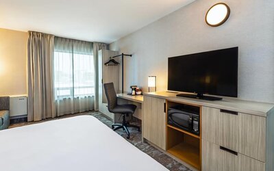 Guest room workspace with a desk, TV, and microwave at Comfort Inn Saskatoon.