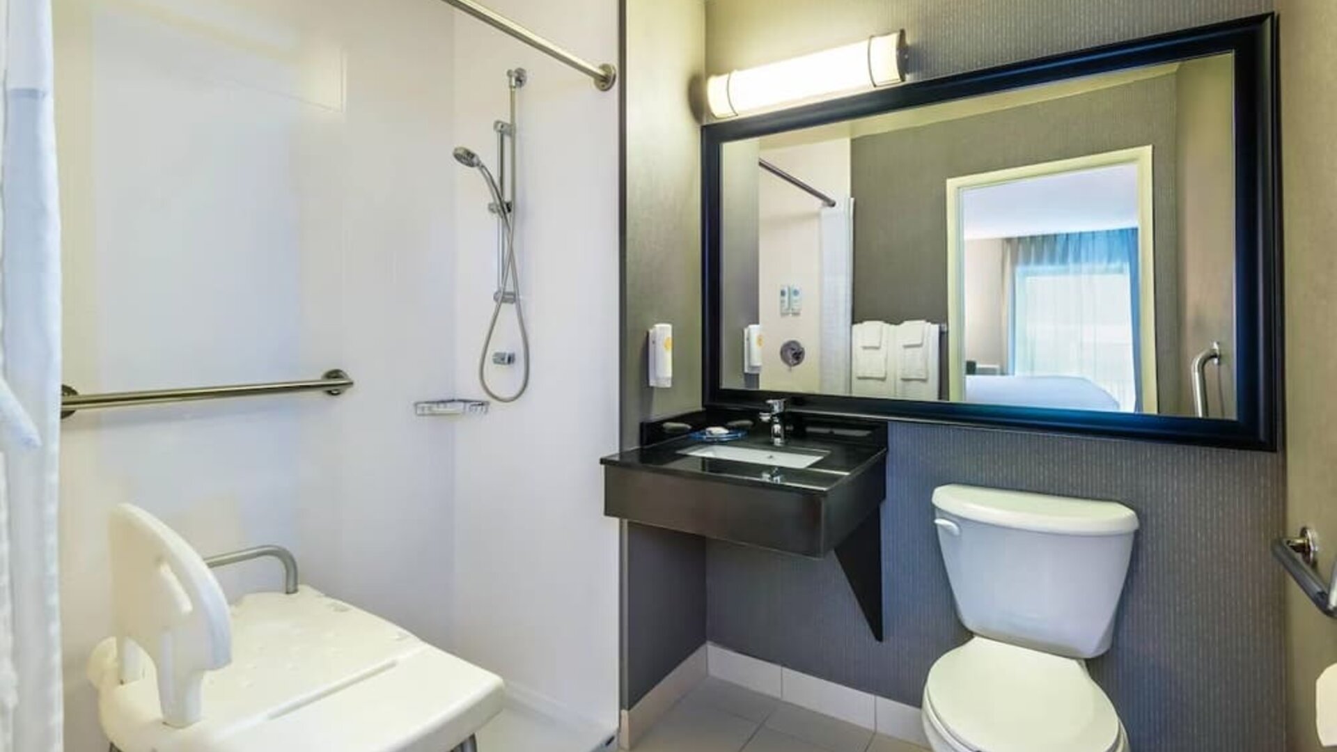 Accessible guest bathroom with a roll-in shower at Comfort Inn Saskatoon.