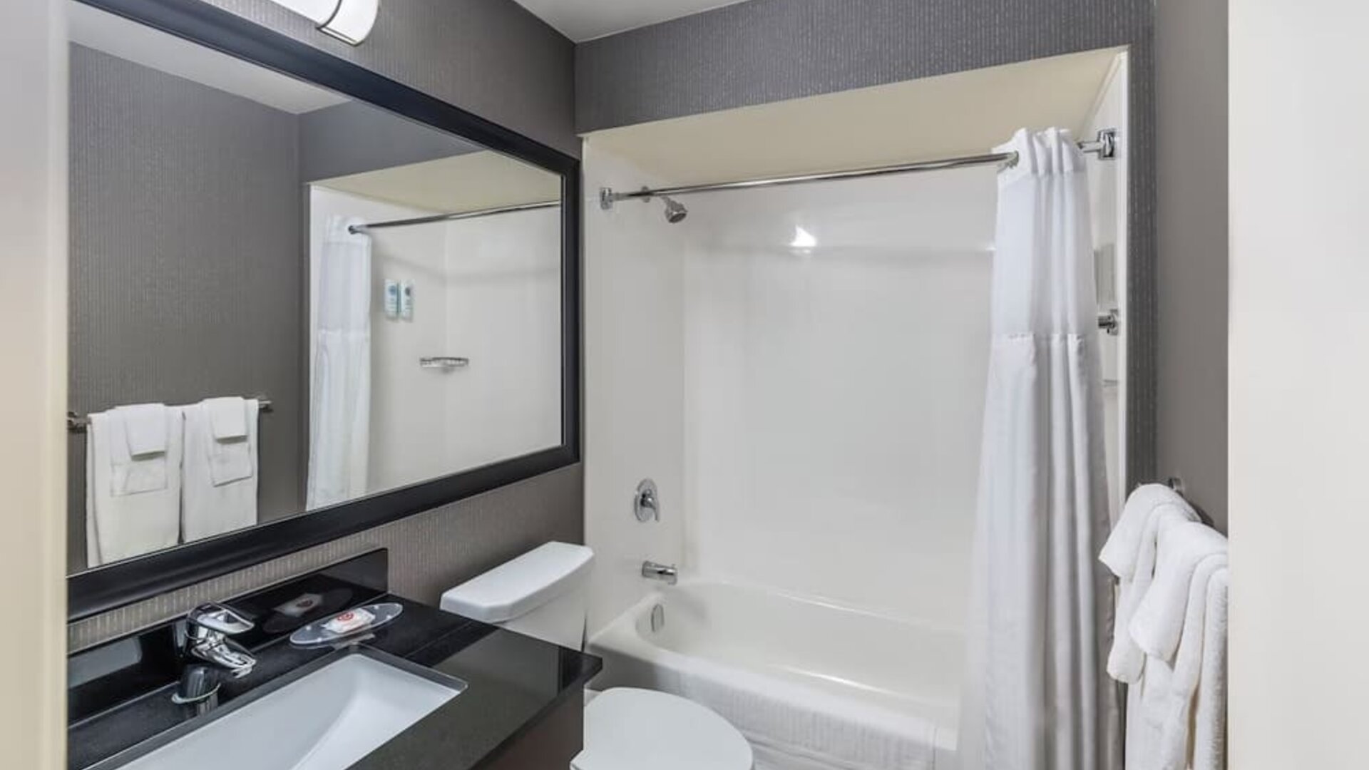 Guest bathroom with a shower and bathtub at Comfort Inn Saskatoon.