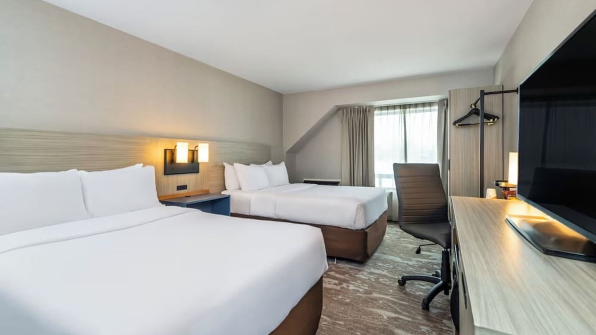 Guest room with two queen beds and a work desk at Comfort Inn Saskatoon.