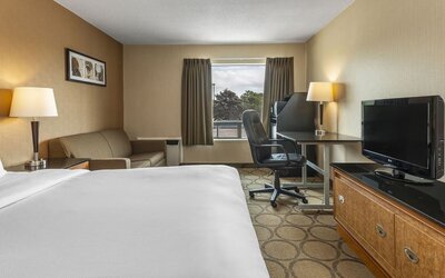 Guest room with a king bed, sofa, and work desk at Comfort Inn Prince Albert.