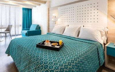 King guest room with breakfast tray, seating area and large windows with full-length curtains at Hotel Casa Blanca.