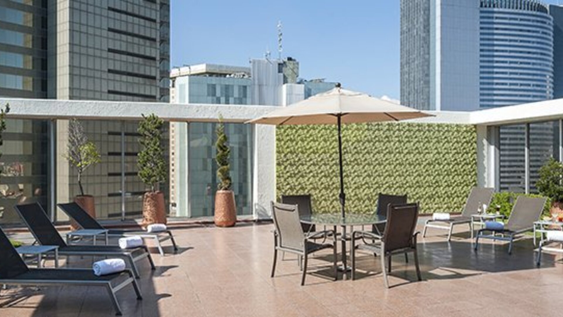 Rooftop terrace with sun loungers, outdoor seating and surrounding city skyline views at Hotel Casa Blanca.