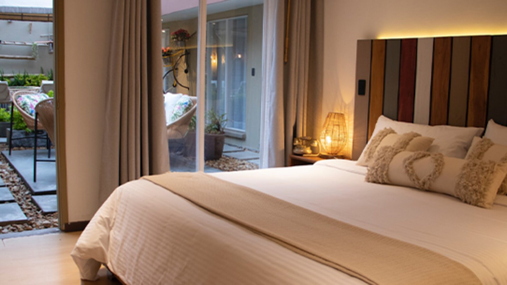 King guest room with decorative pillows and sliding doors opening onto a private courtyard at Marbore Hotel & Spa.