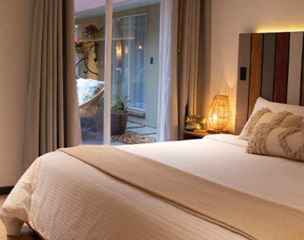 King guest room with decorative pillows and sliding doors opening onto a private courtyard at Marbore Hotel & Spa.