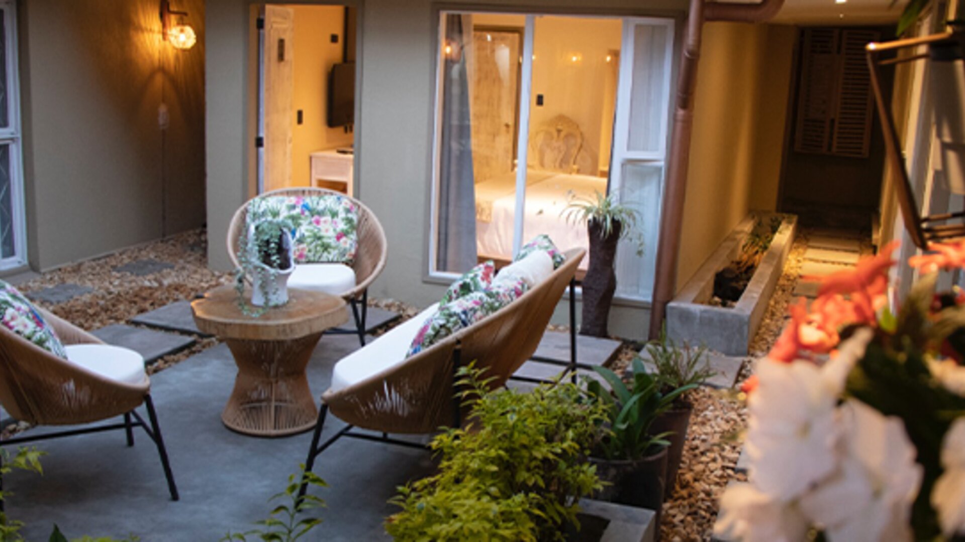 Private courtyard with cushioned outdoor seating surrounded by guest room entrances and plants at Marbore Hotel & Spa.