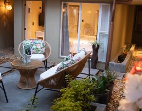 Private courtyard with cushioned outdoor seating surrounded by guest room entrances and plants at Marbore Hotel & Spa.