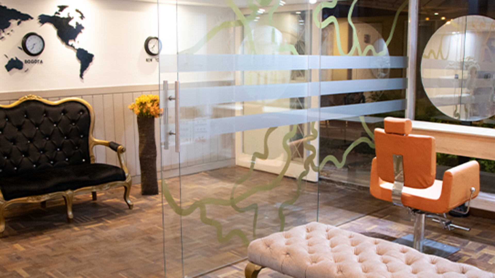 Stylish hotel entrance lounge with glass walls, tufted seating and world map wall décor at Marbore Hotel & Spa.