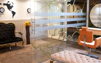 Stylish hotel entrance lounge with glass walls, tufted seating and world map wall décor at Marbore Hotel & Spa.