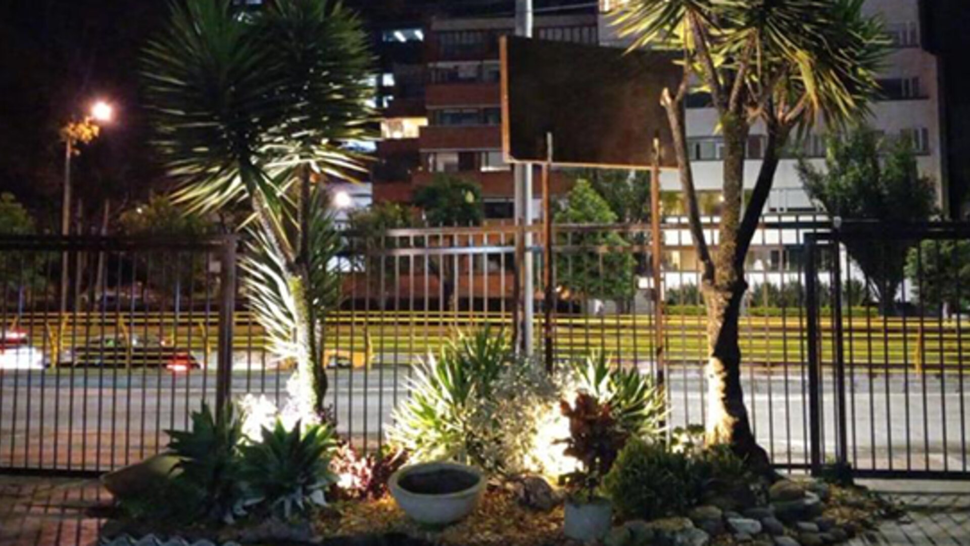 Landscaped garden with tropical plants and illuminated pathways beside the hotel at night at Marbore Hotel & Spa.