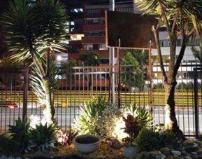 Landscaped garden with tropical plants and illuminated pathways beside the hotel at night at Marbore Hotel & Spa.