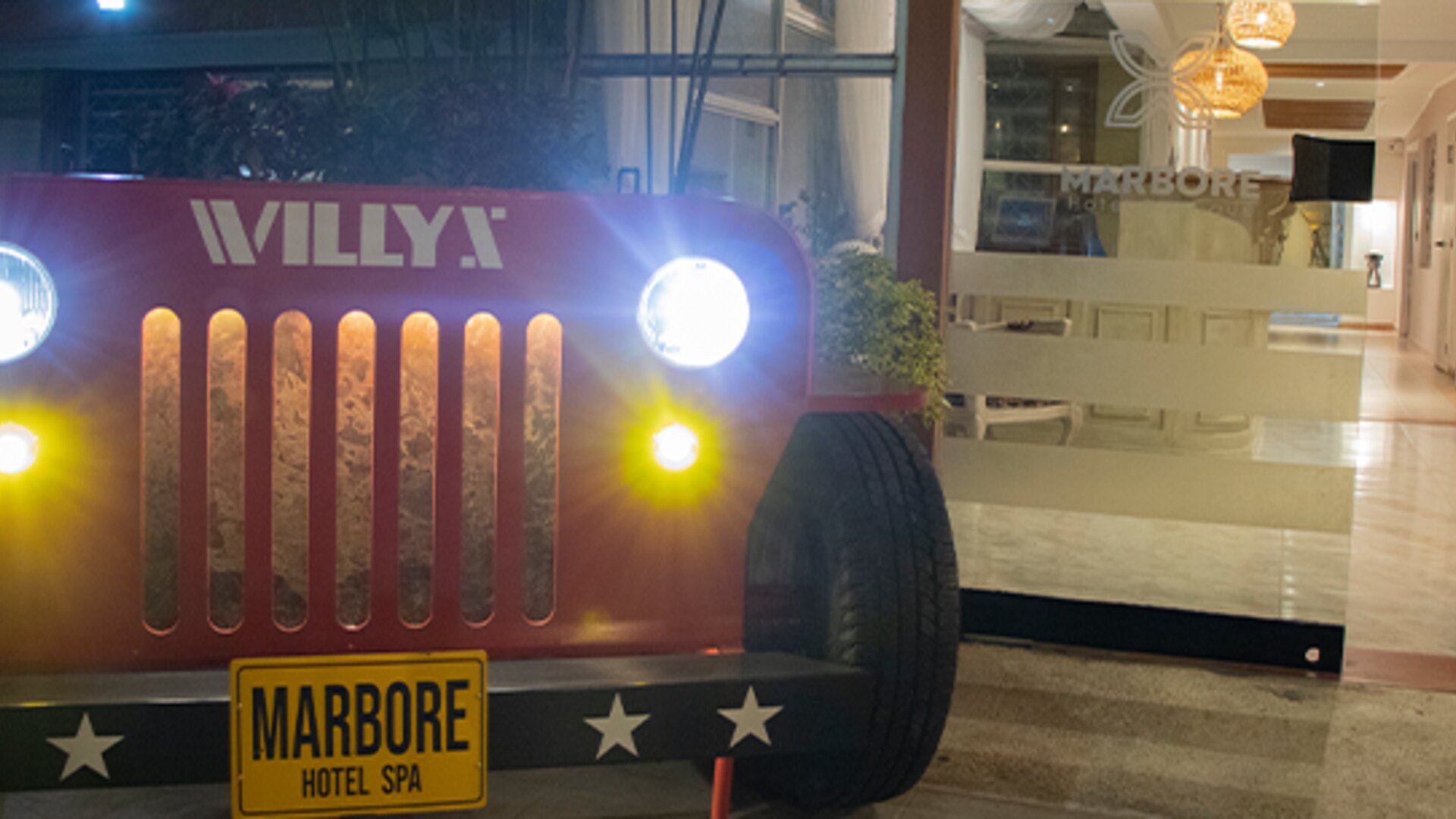 Vintage Jeep-style display with illuminated headlights positioned outside the hotel entrance at Marbore Hotel & Spa.