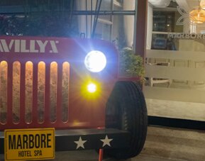 Vintage Jeep-style display with illuminated headlights positioned outside the hotel entrance at Marbore Hotel & Spa.