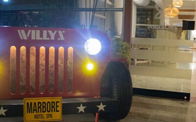 Vintage Jeep-style display with illuminated headlights positioned outside the hotel entrance at Marbore Hotel & Spa.