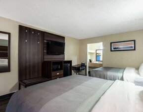 Guest room with two double beds, wall-mounted TV, mini fridge and workspace at Quality Inn Yemassee - Point South I-95.